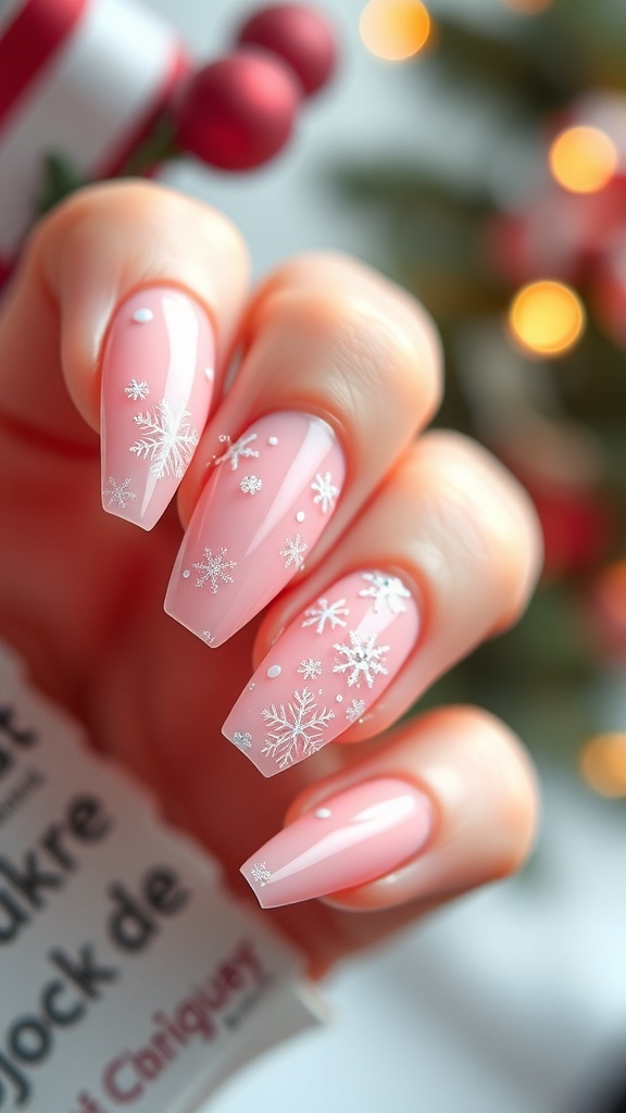 Close-up of pink Christmas acrylic nails with snowflakes and glitter accents.